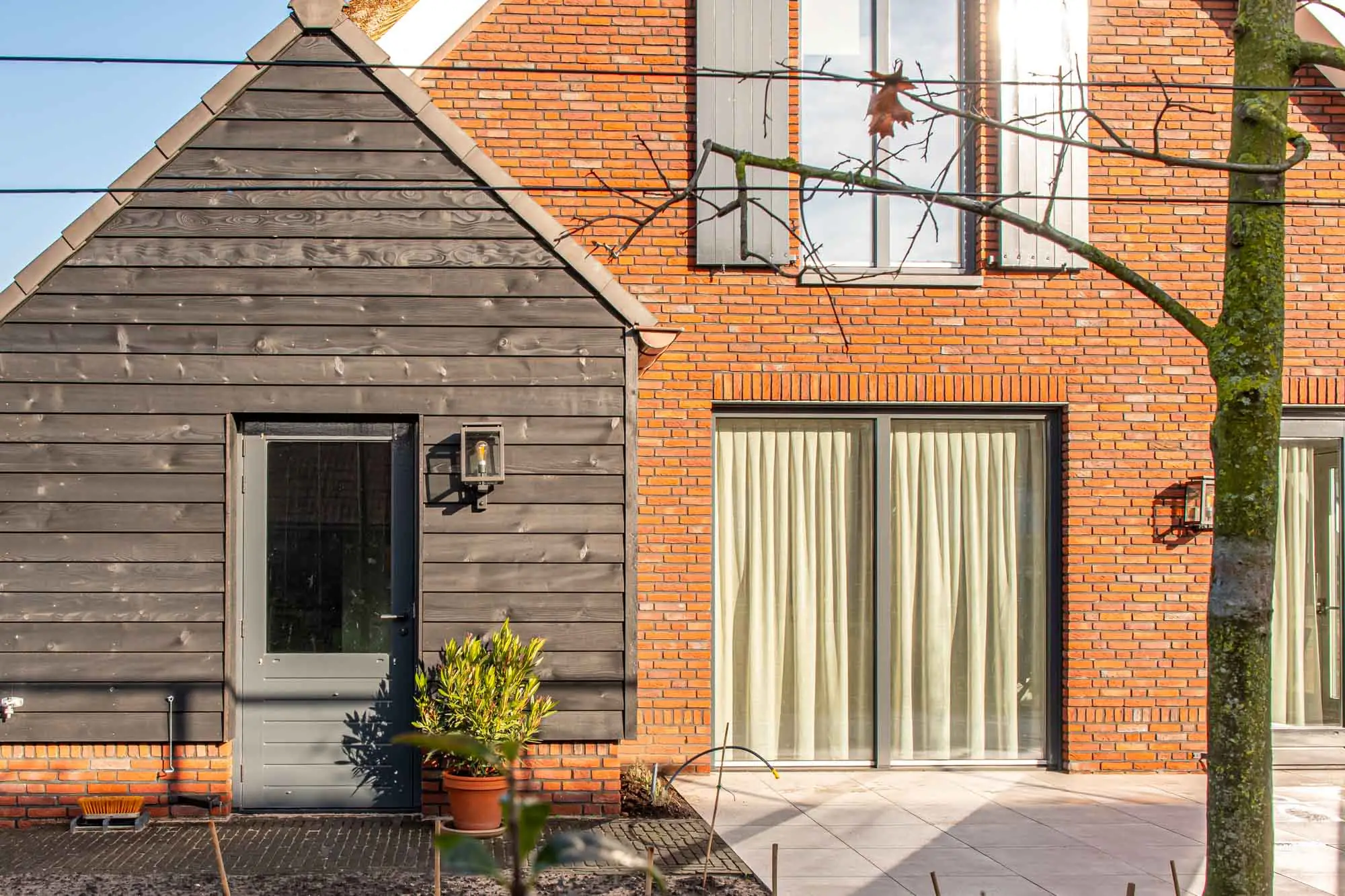 Geschilderde buitendeur en kozijnen in de houten gevel van een villa