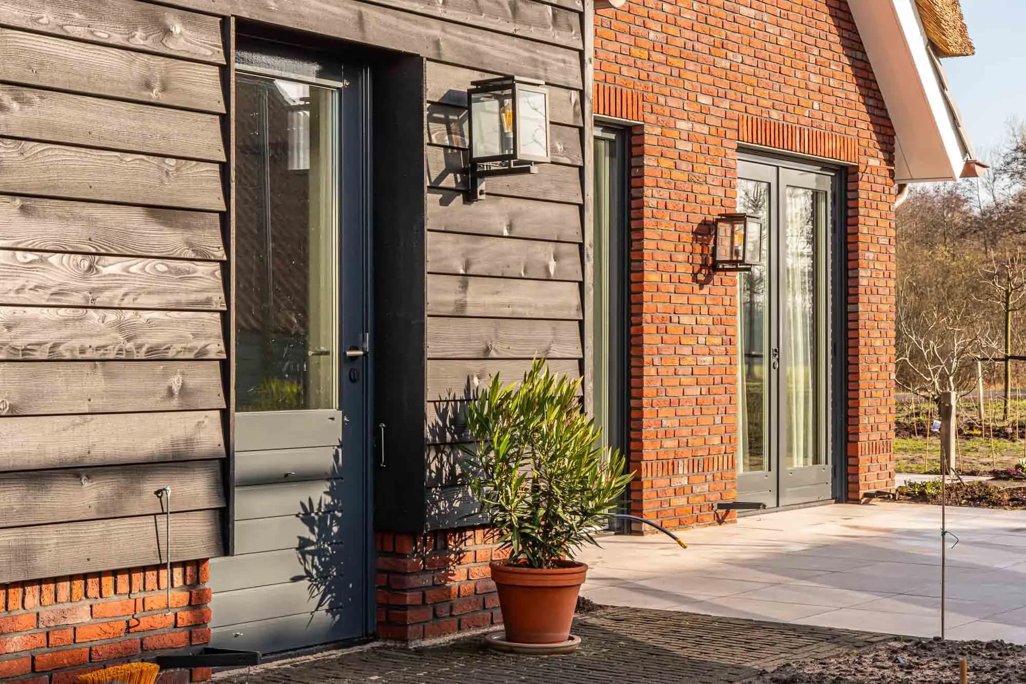 Buitenkozijnen en houten gevelbekleding die onderhoud nodig hebben om houtrot te voorkomen